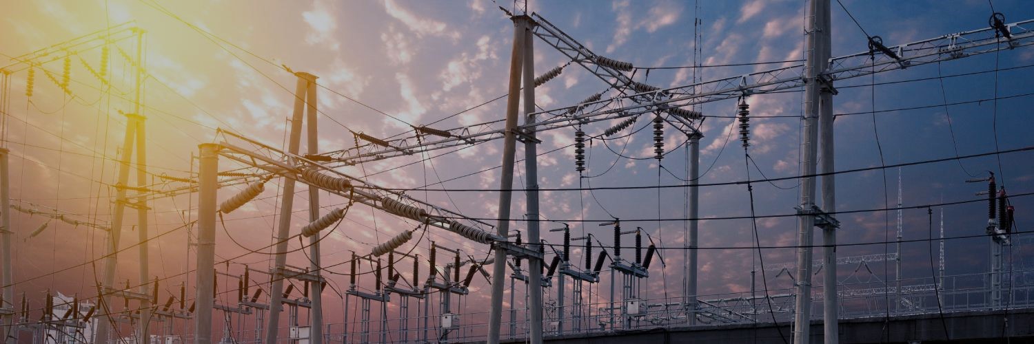 Overhead distribution lines with sun and clouds in background
