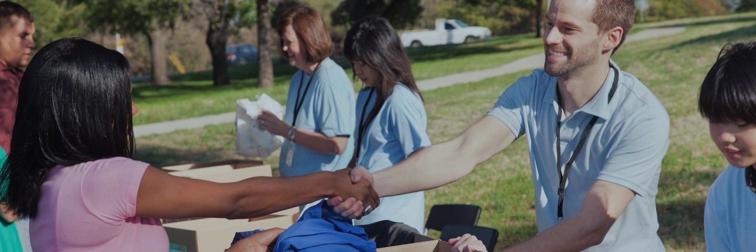 Utility employees greeting people at a table at an outdoor community event 