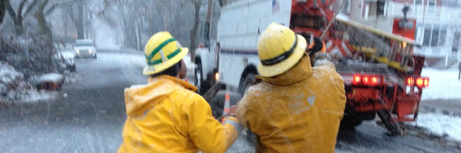 Utility workers and utility truck working on a snowy street