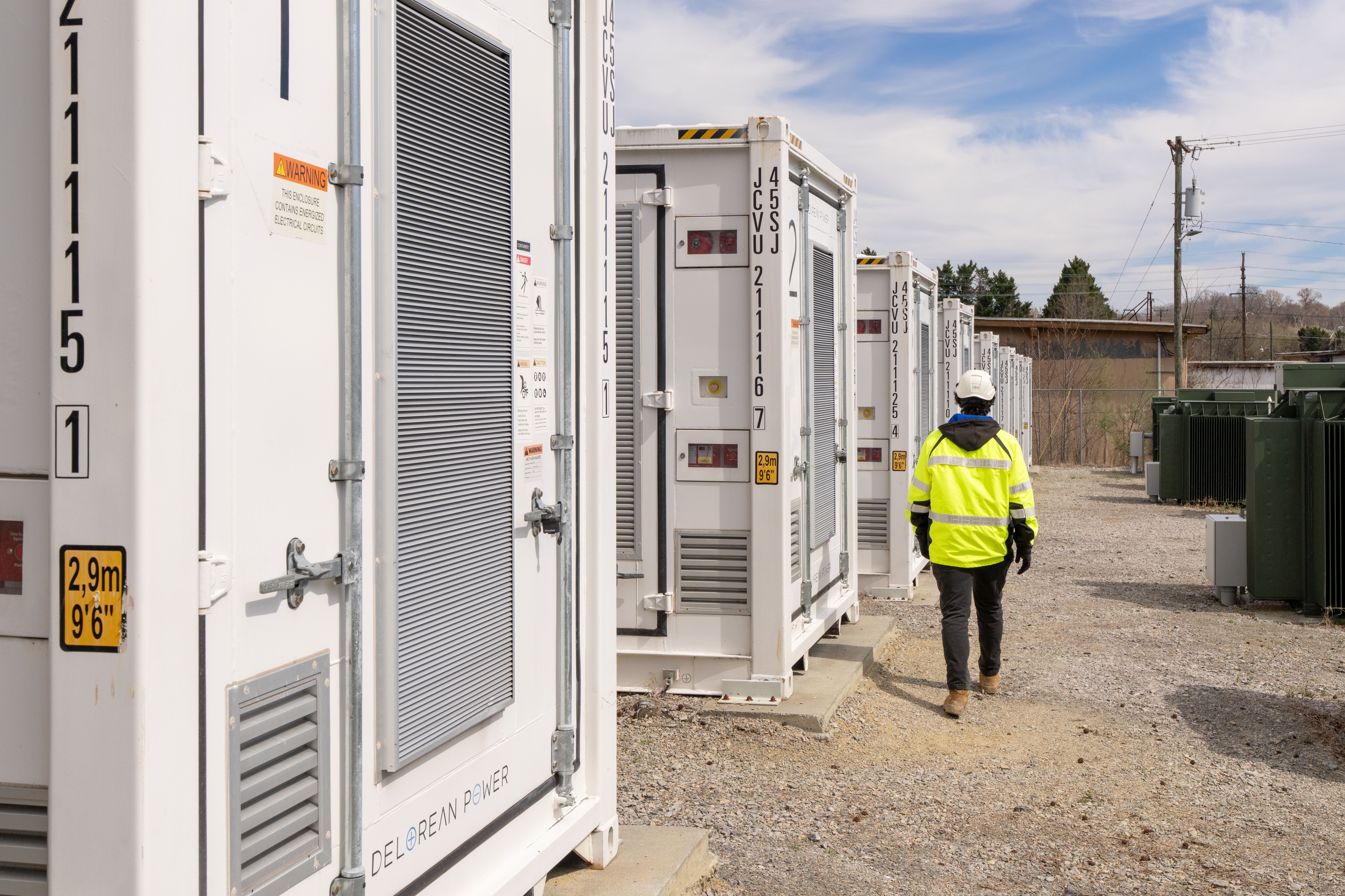A person walks alongside an energy storage facility in Danville, Virginia. Photo by Sanjay Suchack, Lightshift Energy