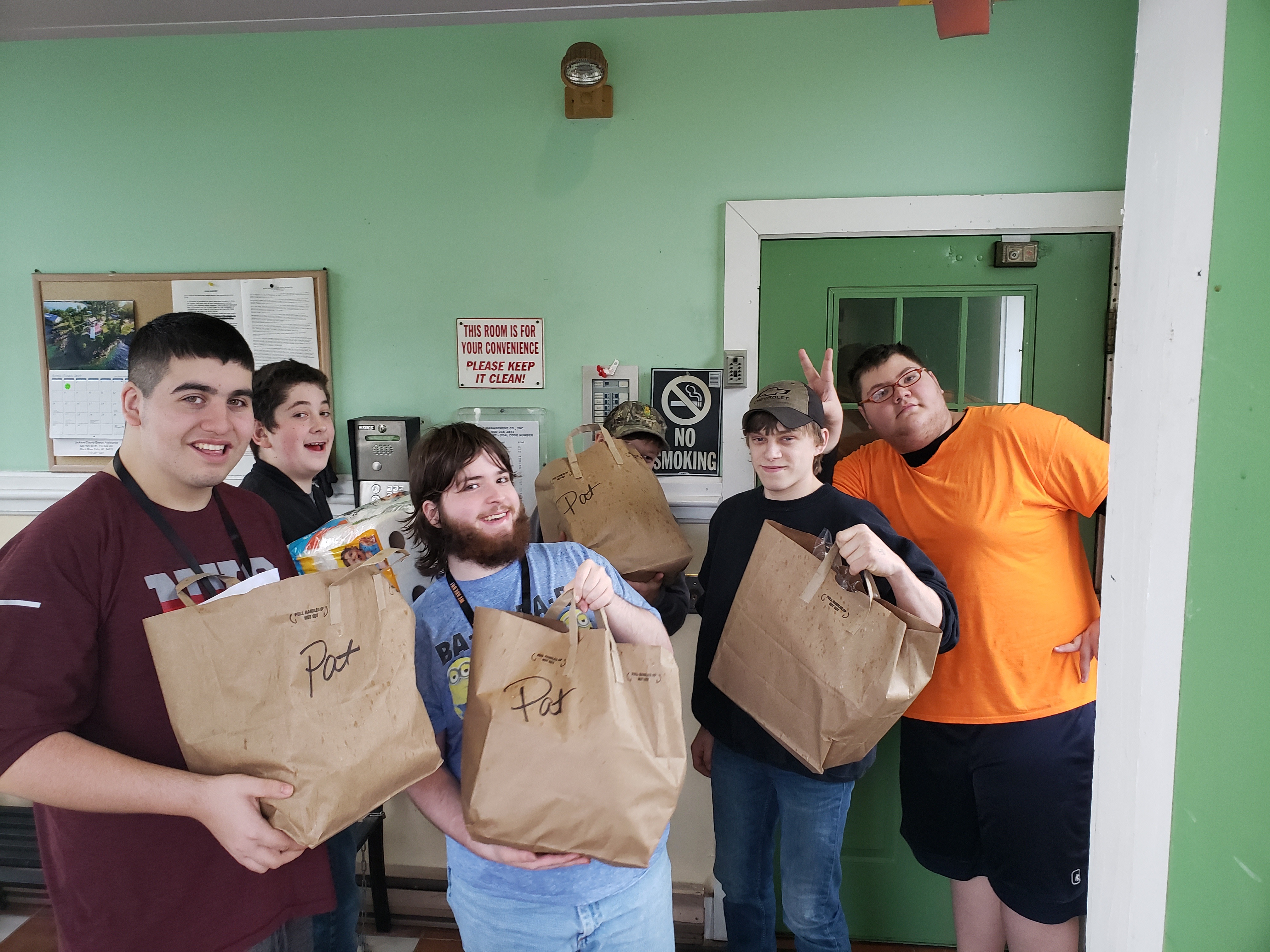 Volunteers holding bags of groceries