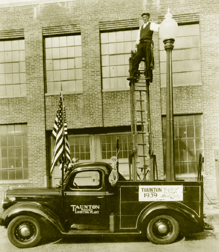 A worker of Taunton Municipal Light replaces a street lamp in 1939