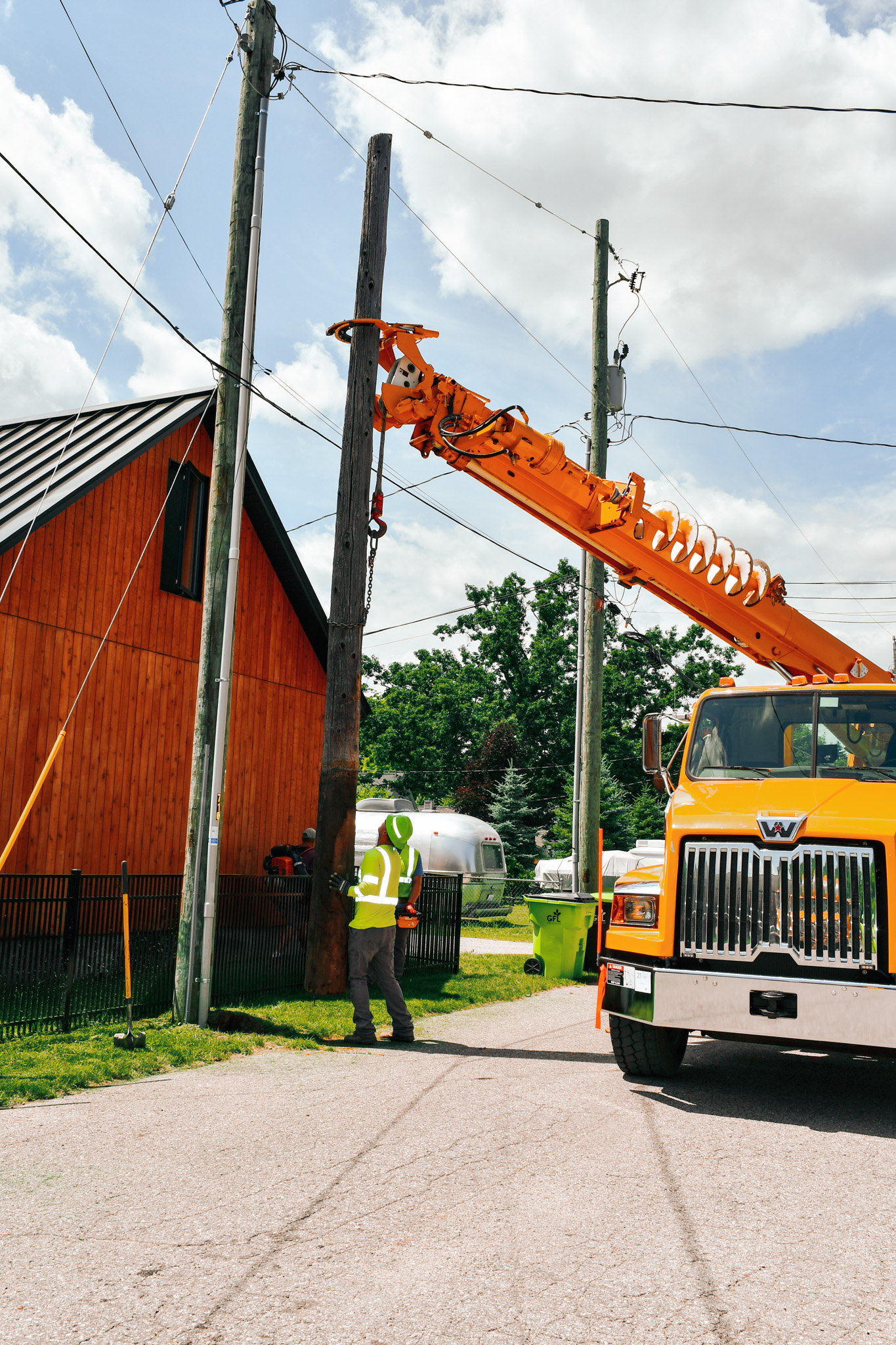 Traverse City linemen setting power poles in place.
