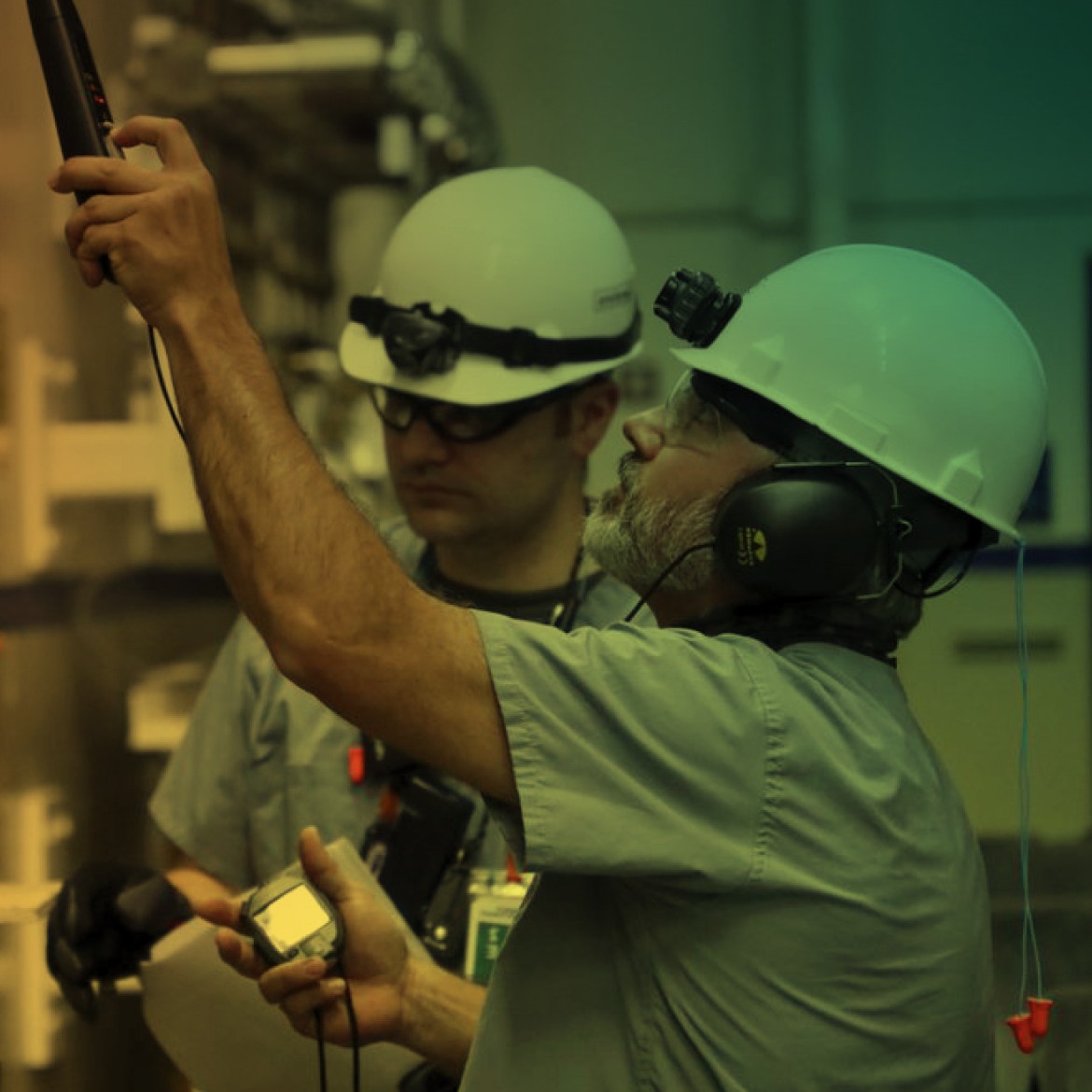 Workers inspecting gauges in a gas plant