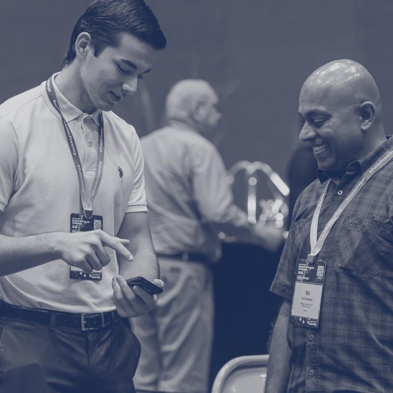 Two people smiling and looking at a phone