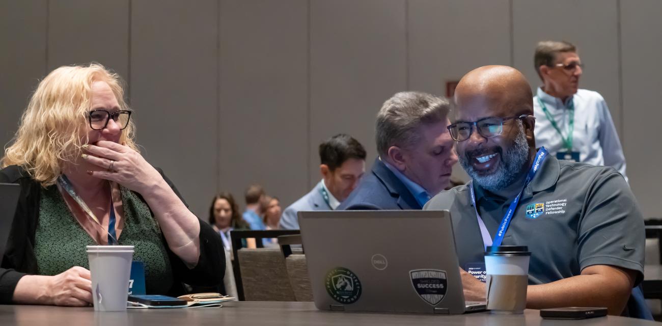 People laughing and looking at a computer