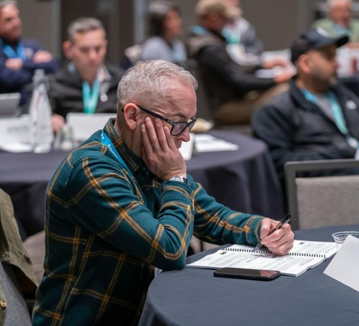 Person taking notes during conference session