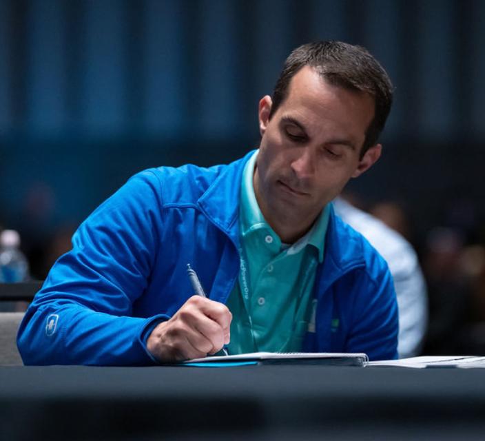 Person taking notes during conference session