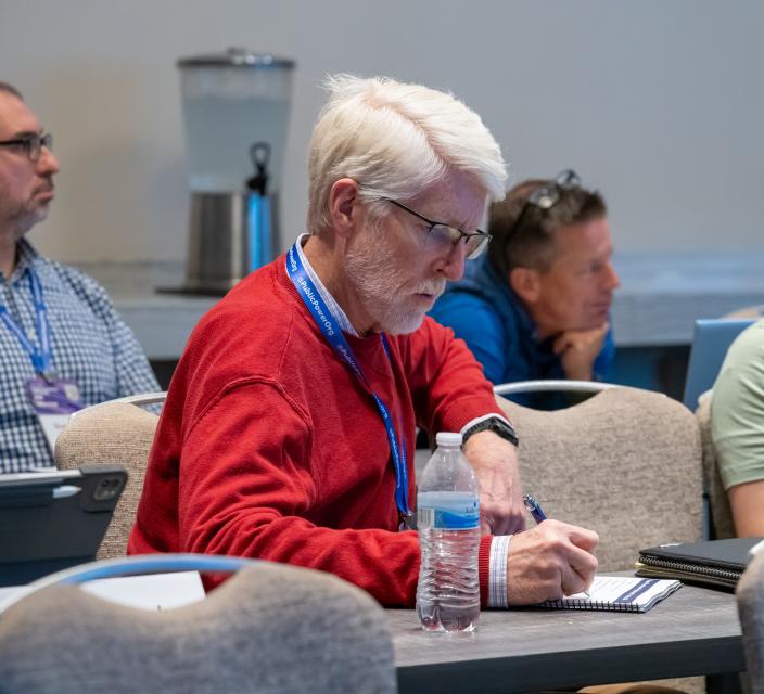 Person taking notes during conference session