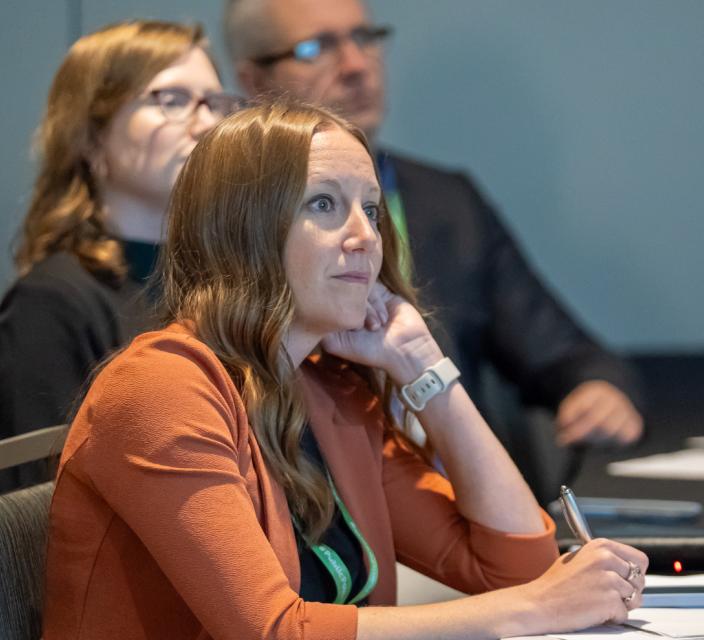 Person listening and taking notes during conference session