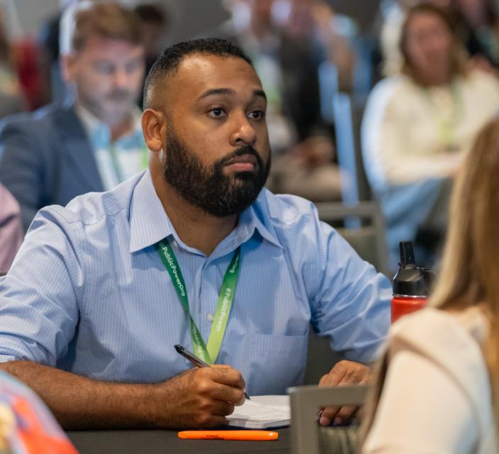 Person listening and taking notes during conference session