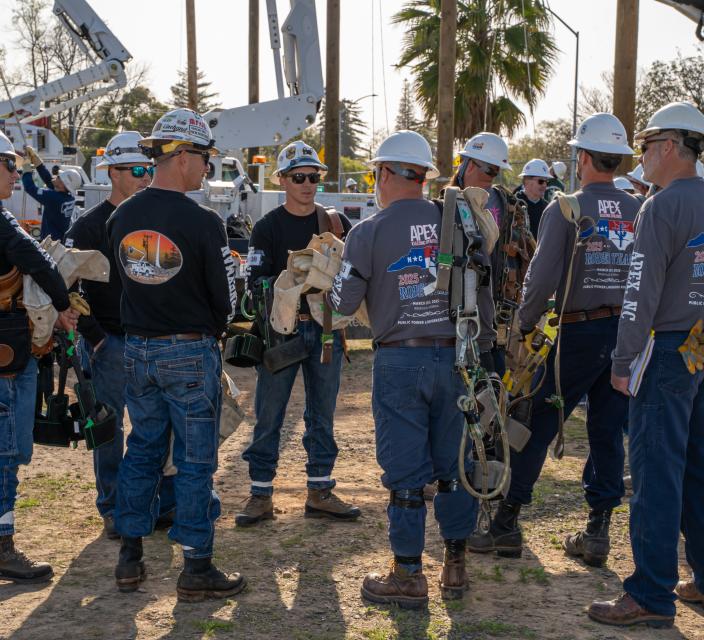 Two teams of lineworkers talking