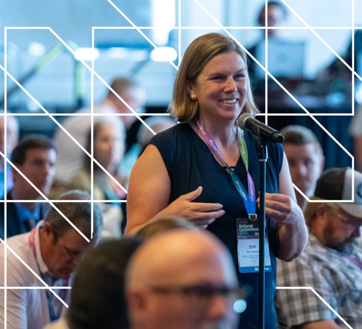 Person speaking into microphone during conference session