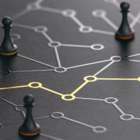 Black chess pawns on a board with a network pattern and a line highlighted in gold