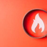 Fire icon inside a magnifying glass on a red background