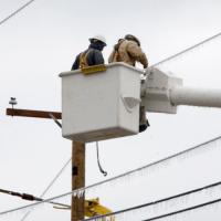 Crew in a bucket truck works to restore frozen lines