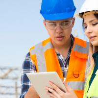 utility workers looking at a tablet