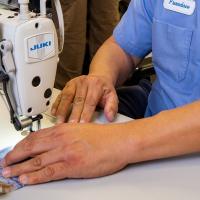 A worker with Los Angeles Department of Water and Power sews a cloth mask