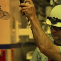 People in hardhats examining machinery