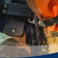 Close-up image of a lineworkers belt overlaid with a blue-and-green swoosh