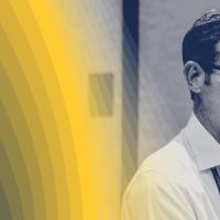 Black-and-white photo of person speaking into a microphone