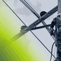 Lineworker atop utility pole