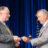 Anthony Cannon passes the gavel to David Osburn.