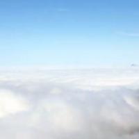 mountaintop peering out above a cloudy sky