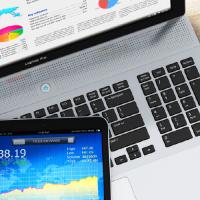 a tablet on top of a computer showing colorful graphs