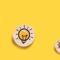 light bulb icons on wooden medallions on a bright yellow background
