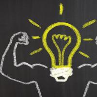chalkboard drawing of a light bulb with strong arms