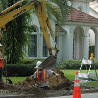 A crew does undergrounding work in front of residences in Winter Park, Florida