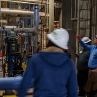 A group on a tour of a power plant as part of PWC Day in Fayetteville, North Carolina