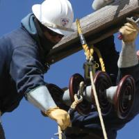 Navajo Tribal Utility Authority workers installing a distribution wire