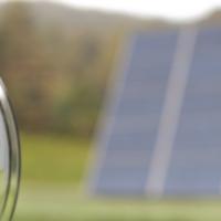 Electric meter with solar panel in the background.