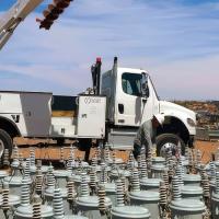 A crew from Provo Power works with NTUA during the Light Up Navajo initiative in 2025. An array of pole mount transformers is in the foreground.