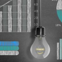 light bulb in front of chalk board of charts