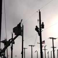 Competing lineworkers silhouetted against a foggy sky.