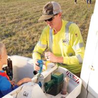 A Lincoln Electric System crew member assists kids in a bucket truck during a community event