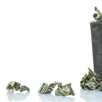 Garbage can with wadded up dollar bills
