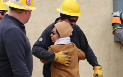 Navajo Nation resident hugs volunteer lineworker crews participating in Light Up Navajo in 2019