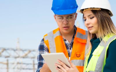 utility workers looking at a tablet