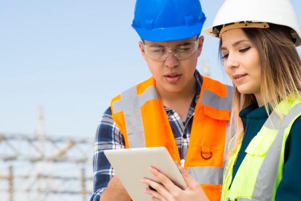 utility workers looking at a tablet