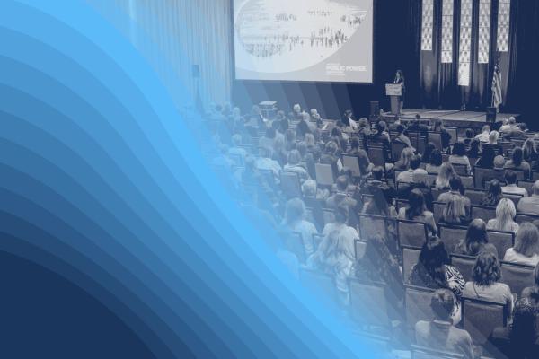 Black-and-white image of people in a large conference session with a blue graphic overlay
