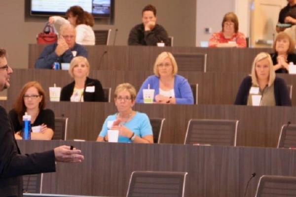 a man speaking to a classroom