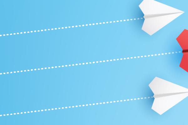 three paper airplanes with dotted line trails