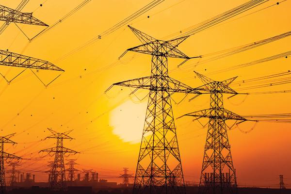 the sun behind transmission towers in an orange sky