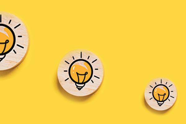 light bulb icons on wooden medallions on a bright yellow background