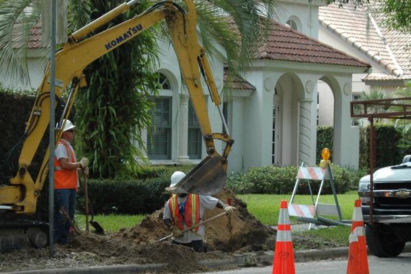 A crew does undergrounding work in front of residences in Winter Park, Florida