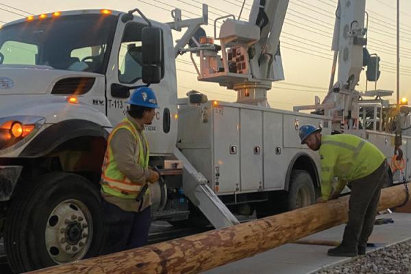 Austin Energy lineworkers setting up a new electrical pole